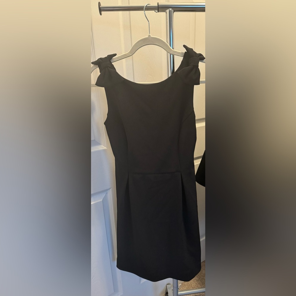 Ava black, lined cocktail length dress with bow details on shoulders.